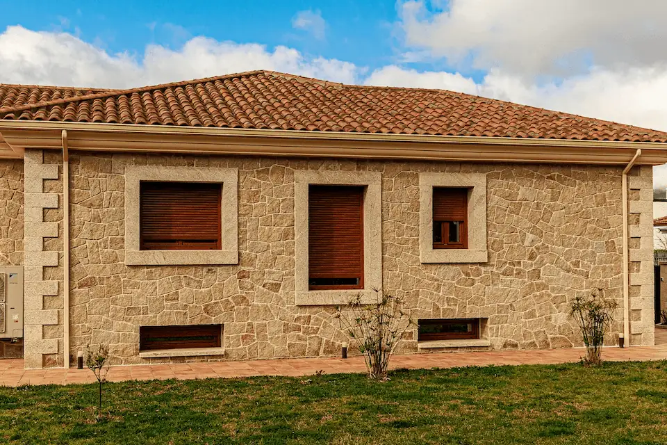 Escalera y columna de granito con acabado rústico abujardado