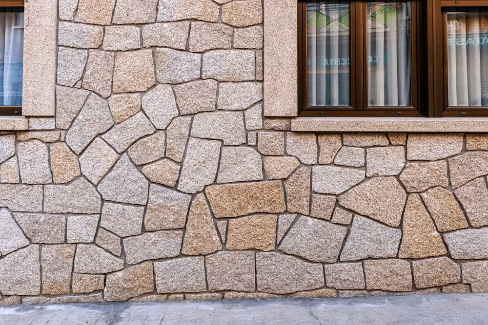 Zócalo rústico recercado de granito rubio abujardado